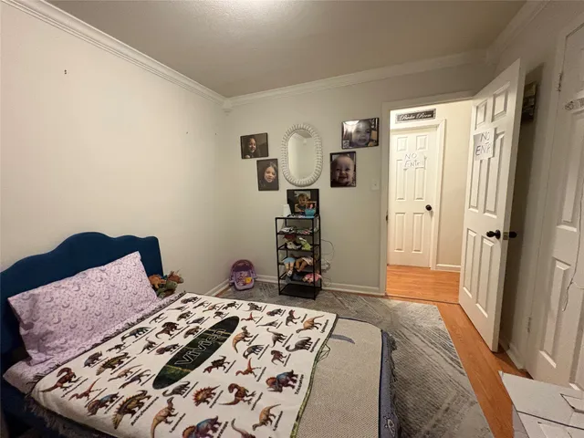 a bedroom with a bed and a dresser with rug