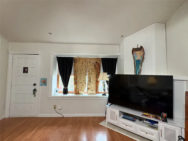 a living room with flat screen tv and a window