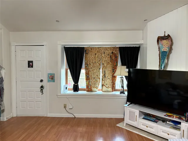 a living room with flat screen tv and a window