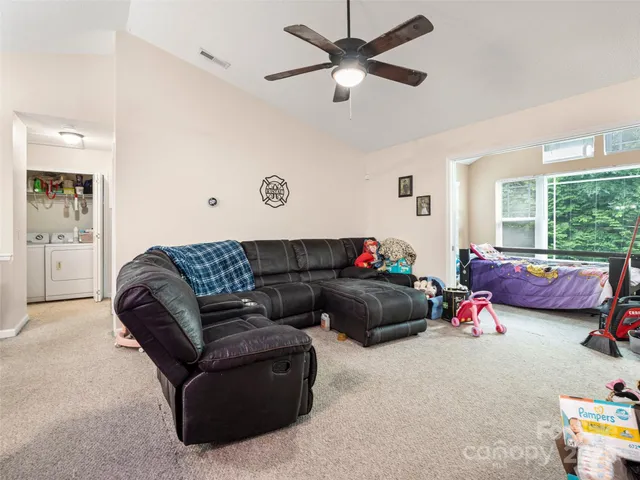 a living room with furniture kitchen view and a window