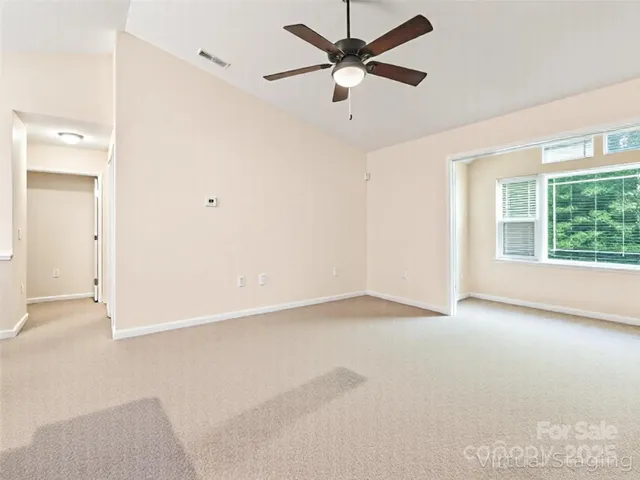 an empty room with a window and a fan