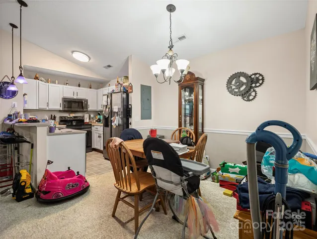 a view of a dining room with furniture and chandelier