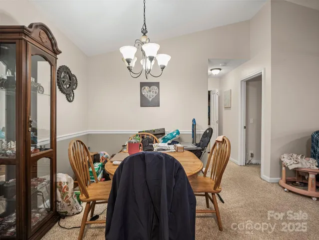 a view of a dining room with furniture and chandelier