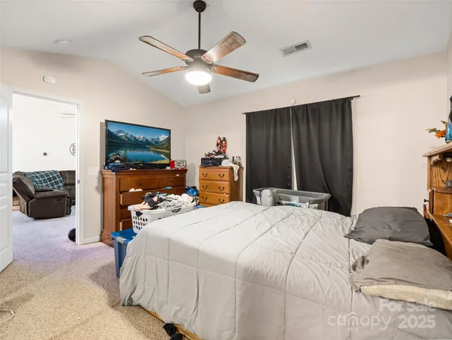 a bedroom with a bed large mirror and dresser