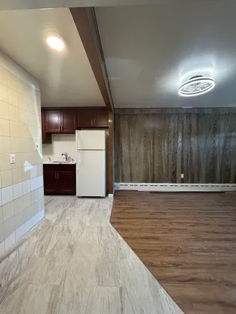 a view of a refrigerator in kitchen and wooden floor