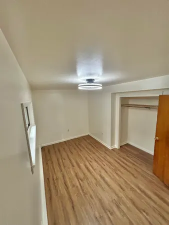 a view of empty room with wooden floor
