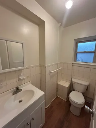a bathroom with a toilet a sink and mirror