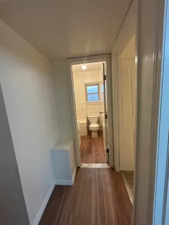 a view of a room with wooden floor and a bathroom