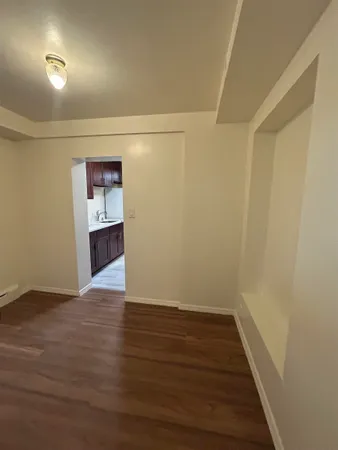 a view of an empty room with wooden floor