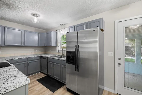 a kitchen with a sink a refrigerator and cabinets