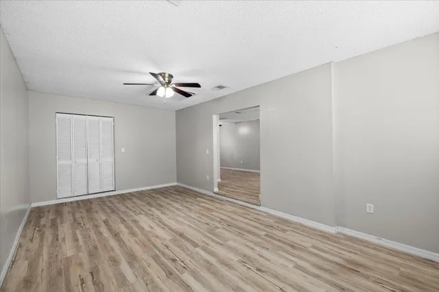 a view of an empty room with wooden floor