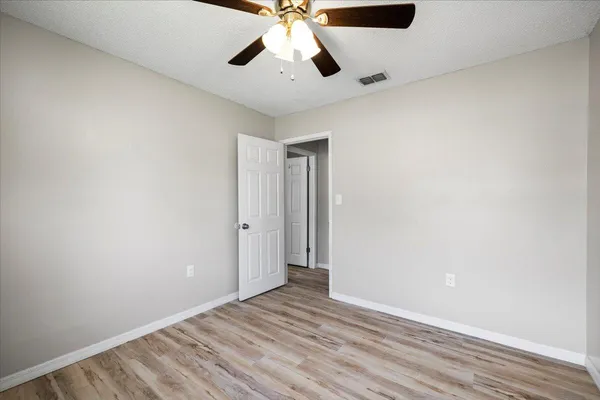 a view of an empty room with wooden floor