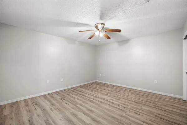 a view of a room with wooden floor and ceiling fan