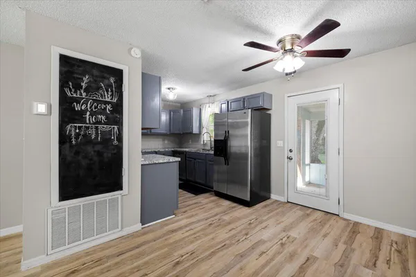 a kitchen with stainless steel appliances kitchen island granite countertop a refrigerator and a sink