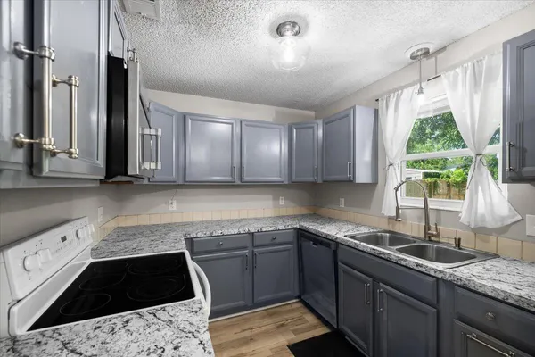a kitchen with a sink stove and cabinets