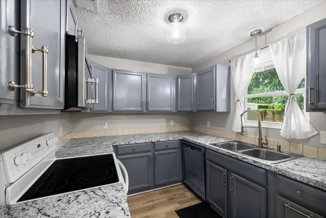 a kitchen with a sink stove and cabinets