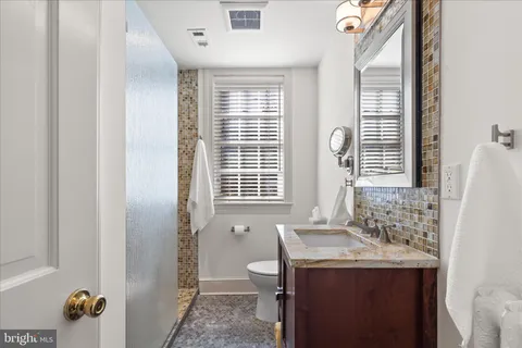 a bathroom with a sink toilet and a mirror