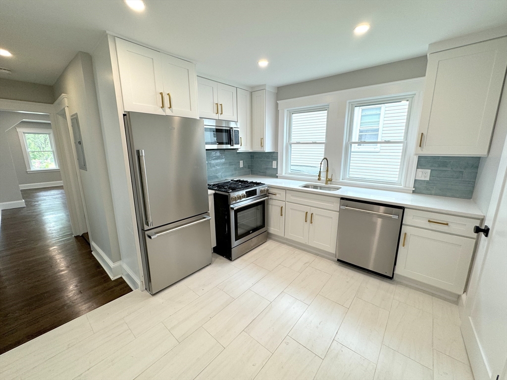 a kitchen with a sink a refrigerator a microwave and cabinets