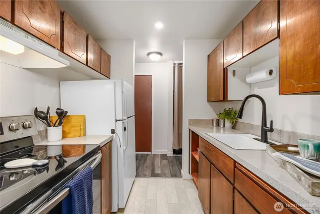 a kitchen with stainless steel appliances a sink stove and refrigerator