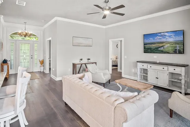 a living room with furniture a ceiling fan and a wooden floor