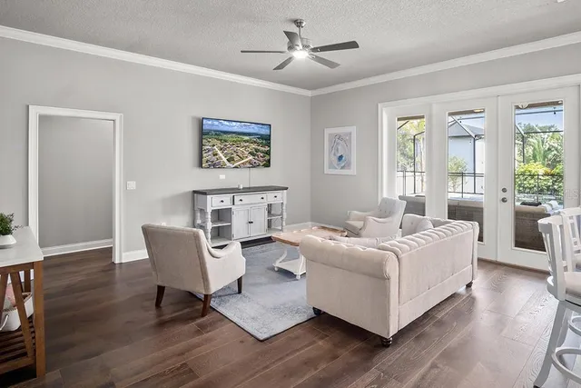 a living room with couches chairs and a potted plant with wooden floor