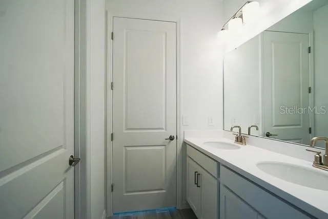 a bathroom with a double vanity sink and mirror