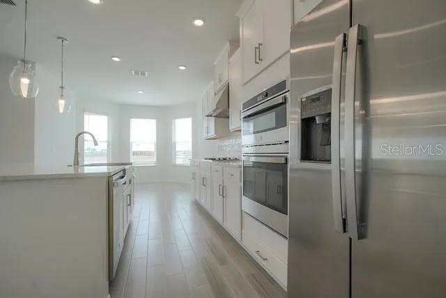 a kitchen with white cabinets and white appliances