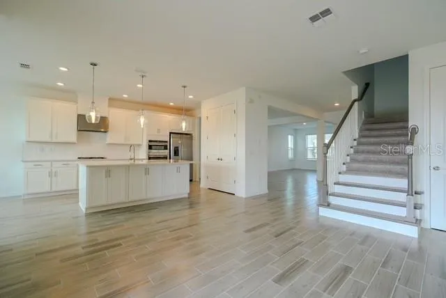 a view of kitchen with wooden floor and electronic appliances