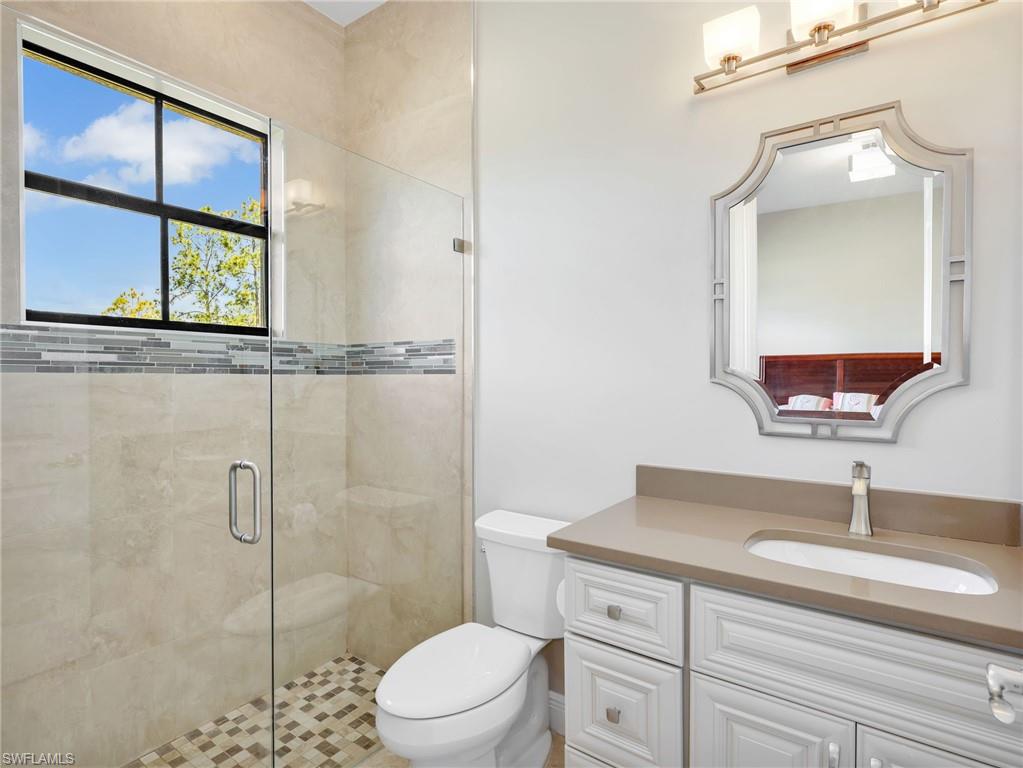 3160 27th Avenue Southwest Naples, FL 34117 - Photo 24 of 43 a bathroom with a toilet a sink a vanity and mirror