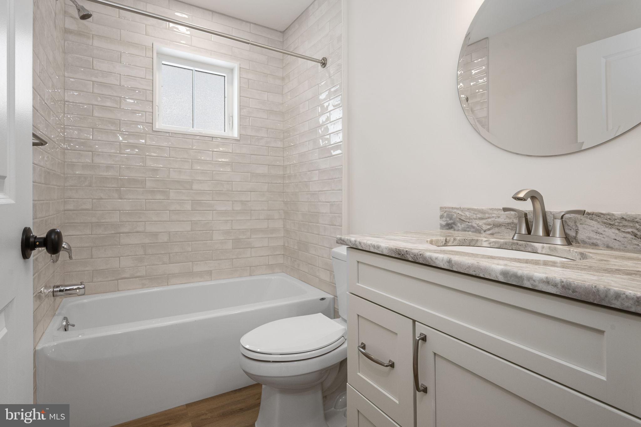 2185 Kimberton Road, Unit 5 Phoenixville, PA 19460 - Photo 17 of 36 a bathroom with a granite countertop toilet a sink and bathtub