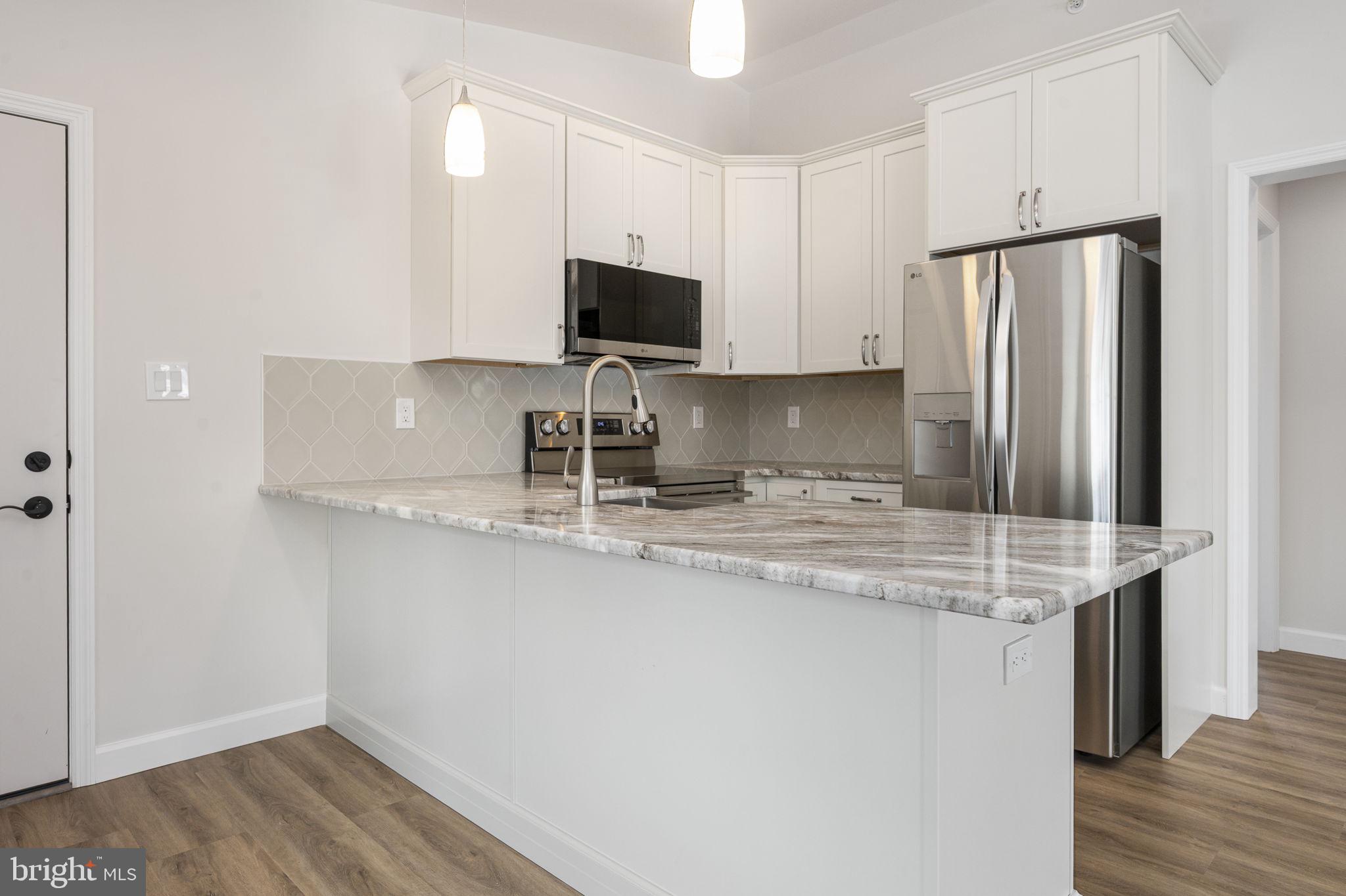 2185 Kimberton Road, Unit 5 Phoenixville, PA 19460 - Photo 19 of 36 a kitchen with stainless steel appliances granite countertop a sink refrigerator and microwave