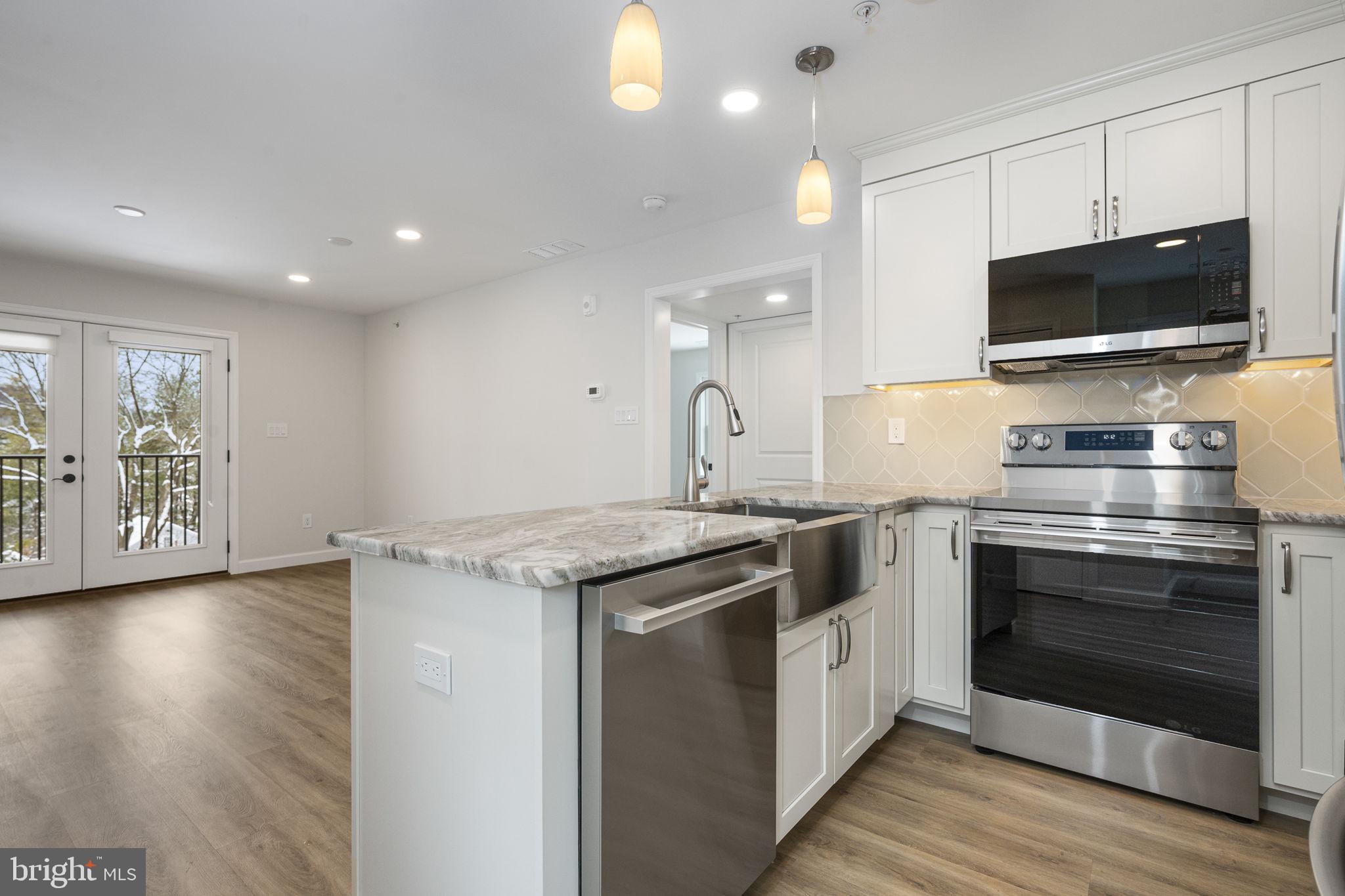 2185 Kimberton Road, Unit 5 Phoenixville, PA 19460 - Photo 7 of 36 a kitchen with stainless steel appliances granite countertop a stove and a microwave