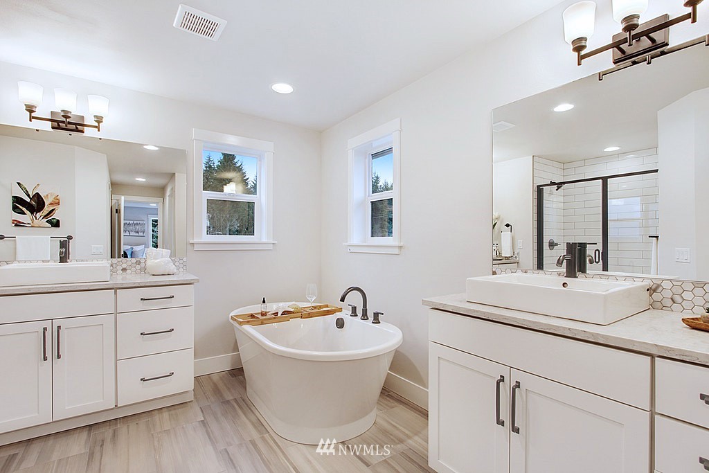 17718 Clover Road Bothell, WA 98012 - Photo 15 of 24 a bathroom with a double vanity sink a mirror a bathtub and