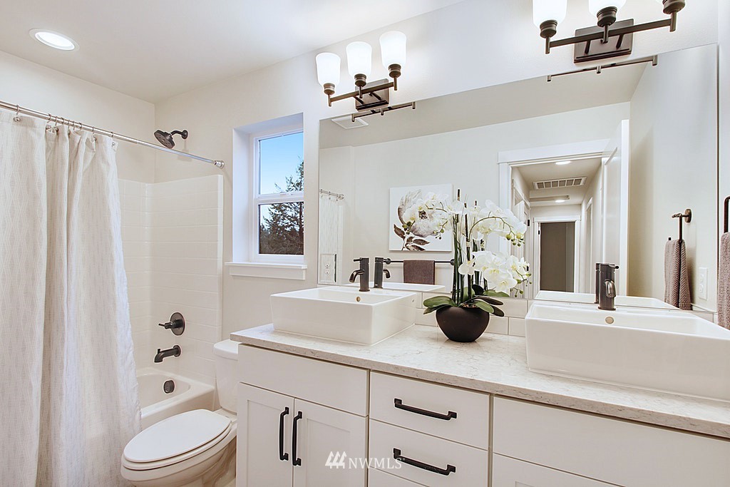 17718 Clover Road Bothell, WA 98012 - Photo 20 of 24 a bathroom with a granite countertop sink a toilet and shower curtain