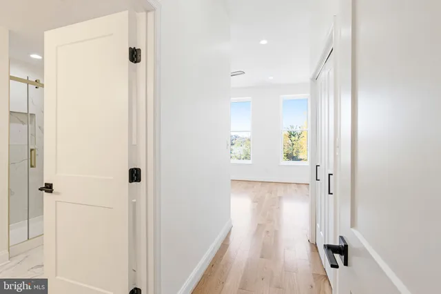 a view of a hallway with wooden floor and closet area