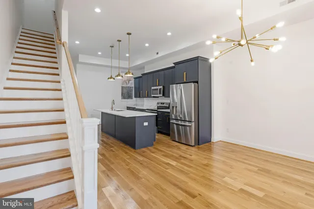 a kitchen with stainless steel appliances kitchen island a refrigerator sink and cabinets