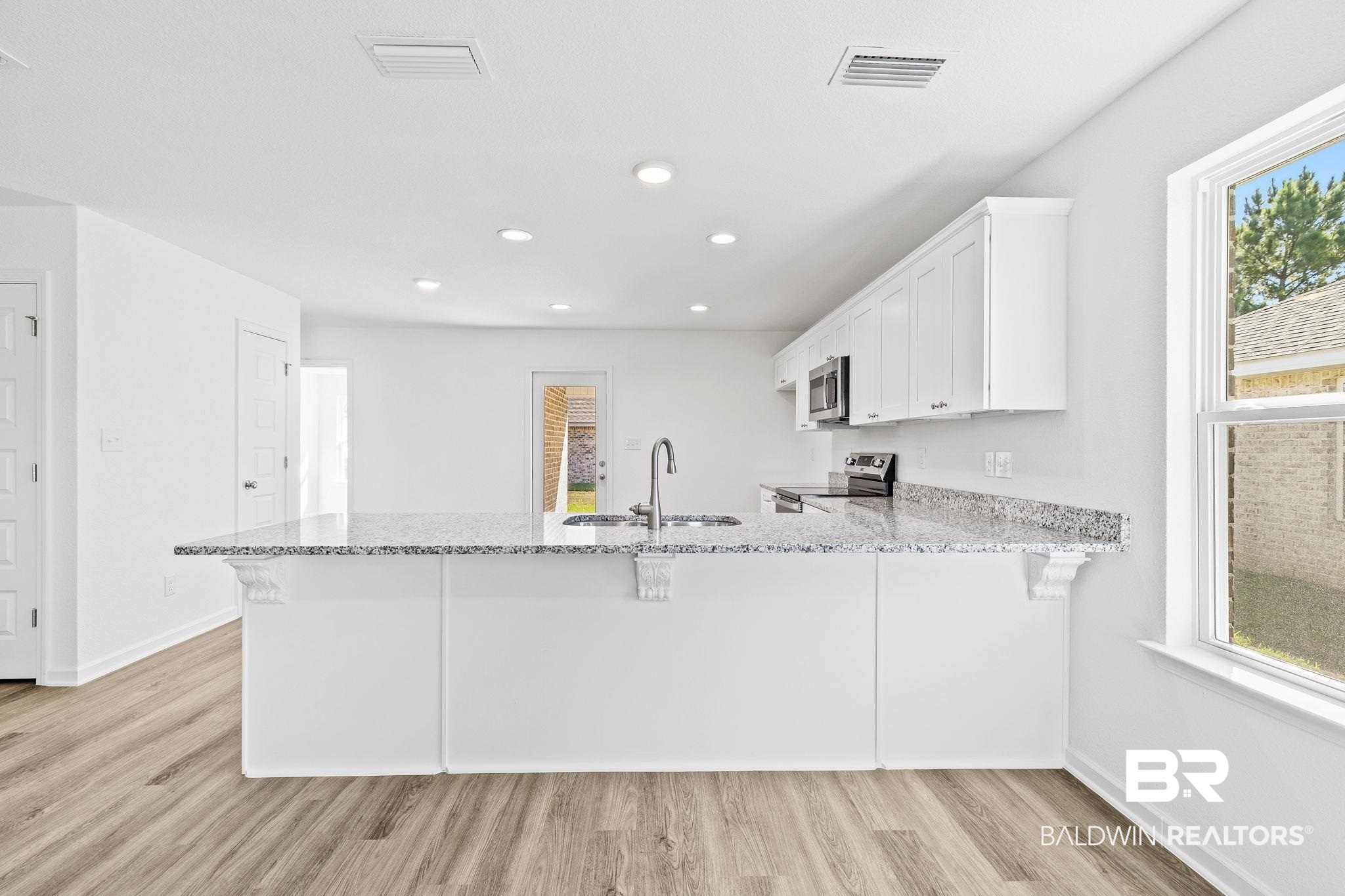 16014 Alabama Avenue Silverhill, AL 36576 - Photo 11 of 50 Kitchen featuring appliances with stainless steel finishes, kitchen peninsula, plenty of natural light, and sink