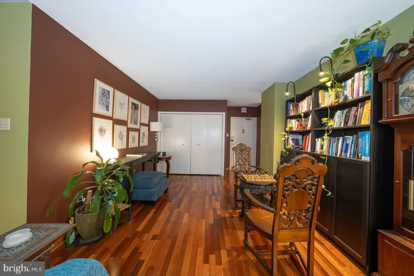 a living room with furniture a bookshelf and a potted plant