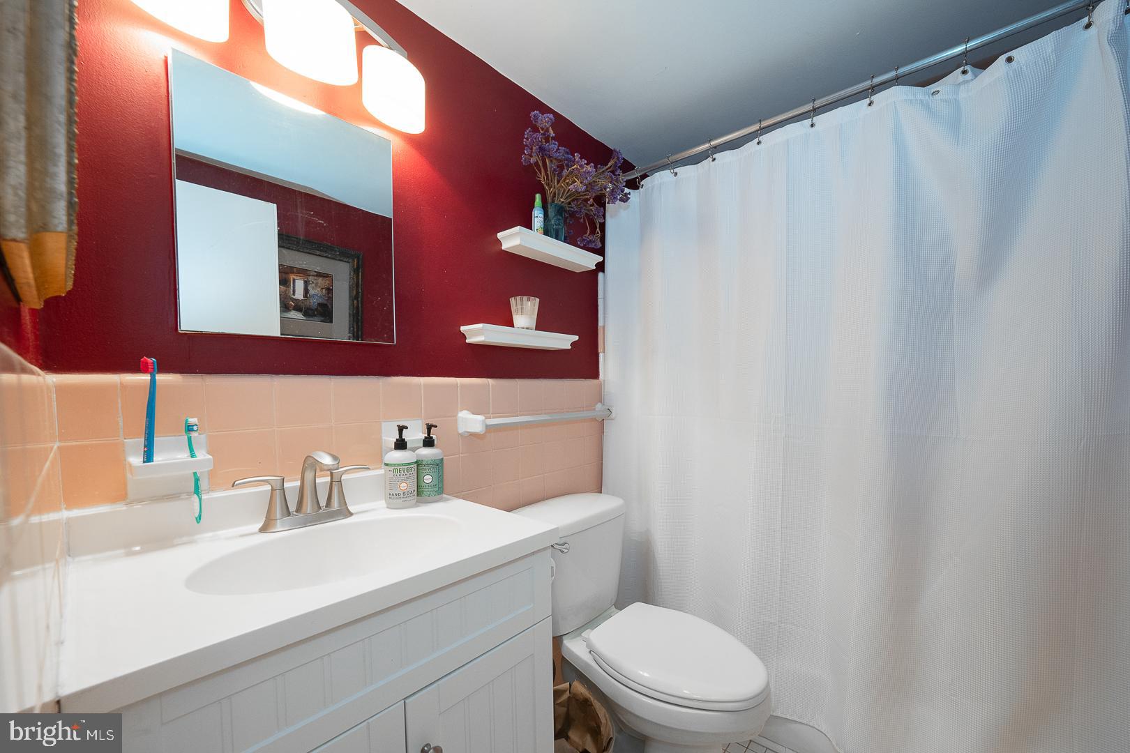 118 South 21st Street, Unit 210 Philadelphia, PA 19103 - Photo 10 of 21 a bathroom with a sink a toilet and a mirror
