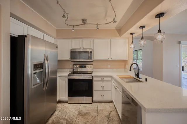 a kitchen with stainless steel appliances granite countertop a refrigerator and a sink