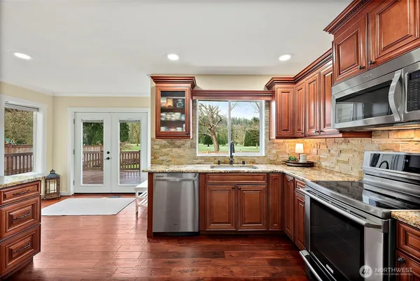 a kitchen with stainless steel appliances granite countertop wooden floors and sink