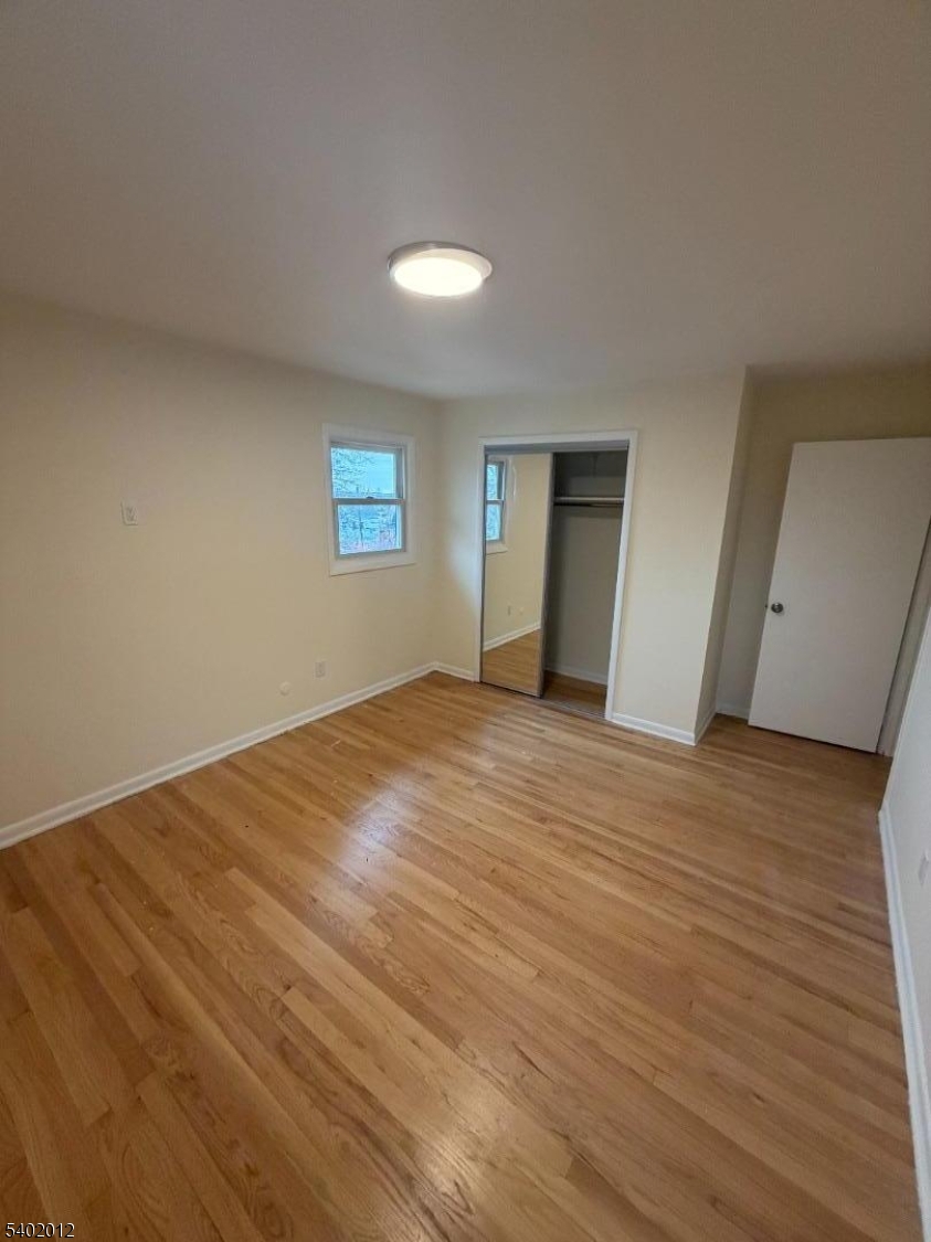 360 Highland Avenue, Unit 2 Passaic, NJ 07055 - Photo 23 of 23 a view of an empty room with wooden floor and a window