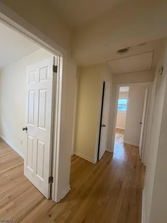 a view of a hallway with wooden floor and entryway