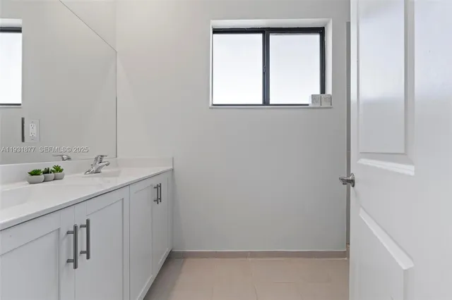 a en suite bathroom with a double vanity sink and a mirror
