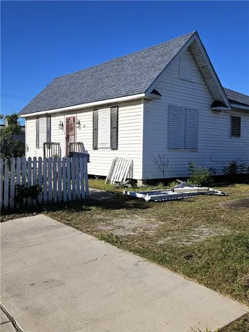 a view of a house with backyard space and wooden fence