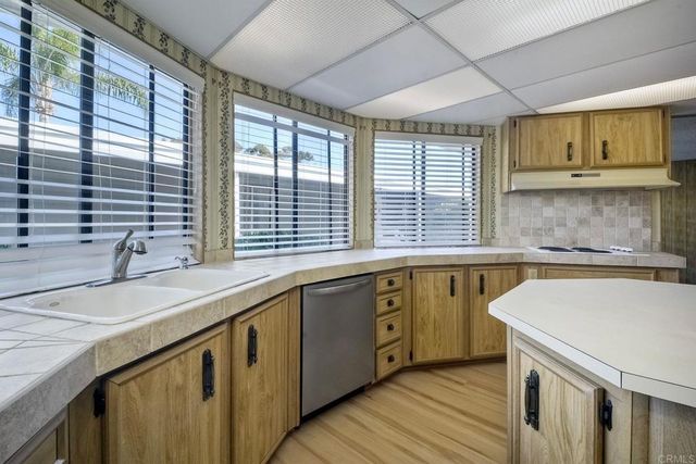 a bathroom with a granite countertop shower sink vanity mirror and toilet