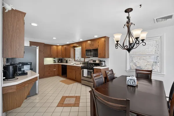 a kitchen with kitchen island granite countertop a stove dining table chairs and a refrigerator