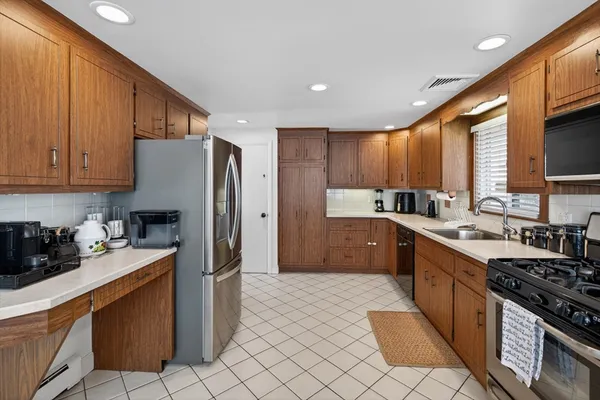 a kitchen with stainless steel appliances granite countertop a refrigerator stove sink and cabinets