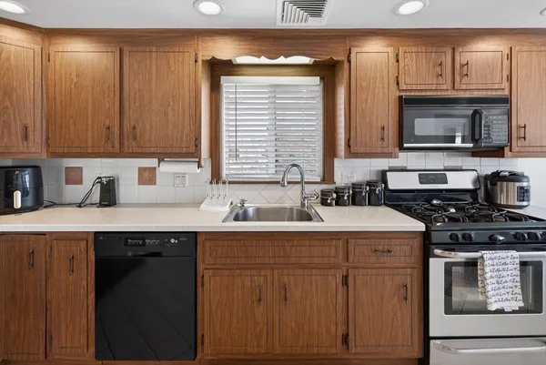 a kitchen with a sink stove top oven and cabinets