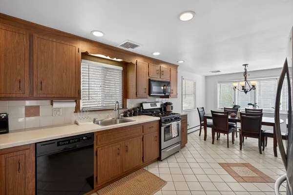 a kitchen with appliances a sink a counter top space and cabinets